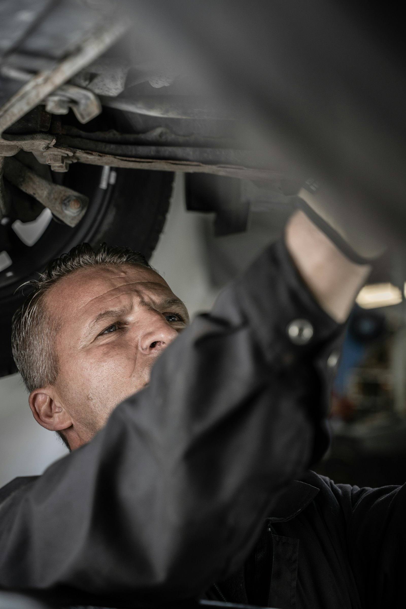 Technicien au travail sous un véhicule
